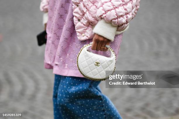 Guest wears a pale pink quilted puffy hoodie puffer jacket, a pale purple embroidered glitter logo pattern shirt from Chanel, a white shopping bag...