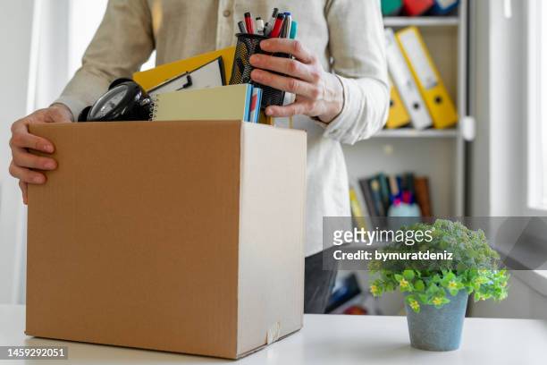sad dismissed worker taking his office supplies with him - employee leaving stock pictures, royalty-free photos & images