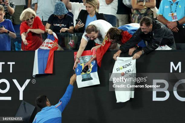 Novak Djokovic of Serbia signs merchandise for spectators in the Quarterfinal singles match against Andrey Rublev during day ten of the 2023...