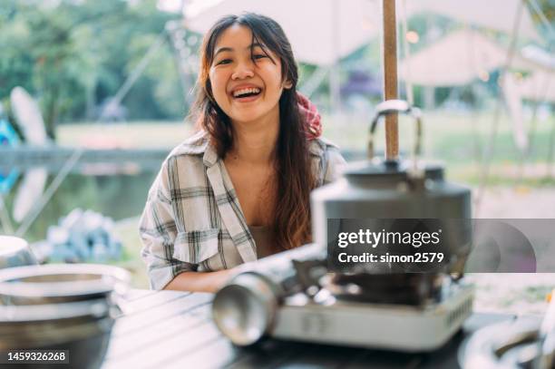 happy young asian women cooking with kettle on gas stove in camp site - boiled stock pictures, royalty-free photos & images