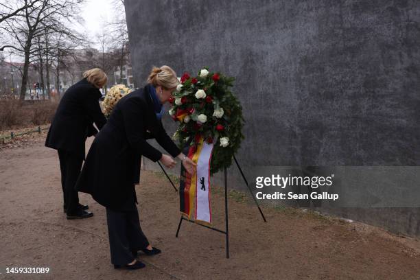 Berlin Governing Mayor Franziska Giffey and Bundestag President Baerbel Bas adjust wreaths at the main memorial that commemorates homosexual victims...