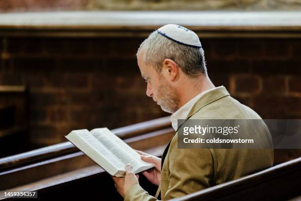 jüdischer mann mit kippa beim lesen des heiligen buches in der synagoge - reading synagogue stock-fotos und bilder