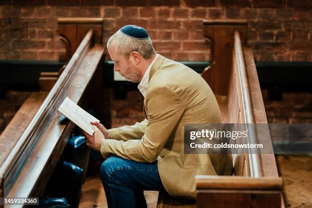 jüdischer mann mit kippa beim lesen des heiligen buches in der synagoge - reading synagogue stock-fotos und bilder