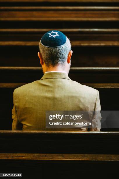 jewish man wearing yarmulke praying in synagogue - judaism stock pictures, royalty-free photos & images
