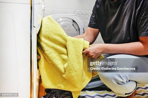 close-up of a woman's hands with a washing machine and a yellow towel - hand wasser stockfoto's en -beelden