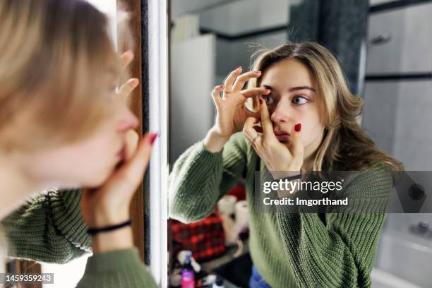 adolescente usa lentes de contacto en el baño - lente de contacto fotografías e imágenes de stock