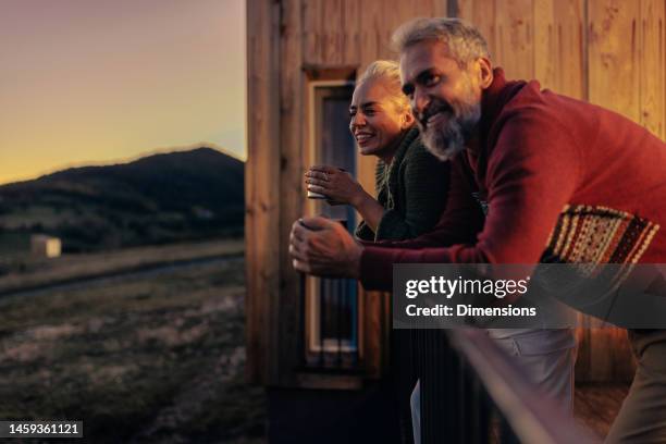mature couple enjoy mountain sunset. - couple having fun stock pictures, royalty-free photos & images