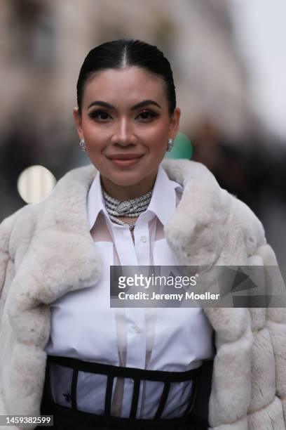 Fashion week guest seen wearing a Bulgari Serpenti sparkling necklace and matching earrings, a white blouse and a beige fur coat before the Dior show...