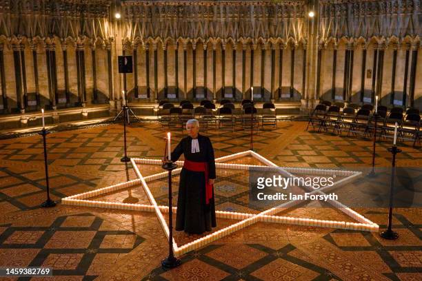 The Reverend Canon Maggie McLean, Canon Missioner at York Minster lights one of the 600 candles shaped as a Star of David on the floor of the Chapter...