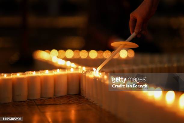 Member of the minster staff lights some of the 600 candles arranged in the shape of the Star of David on the floor of the Chapter House of York...