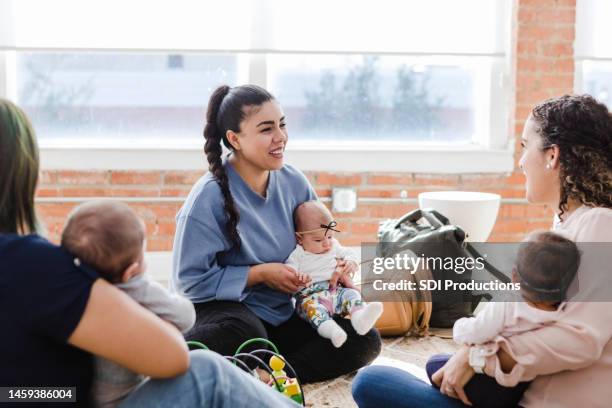 young adult mother talking - baby group stockfoto's en -beelden