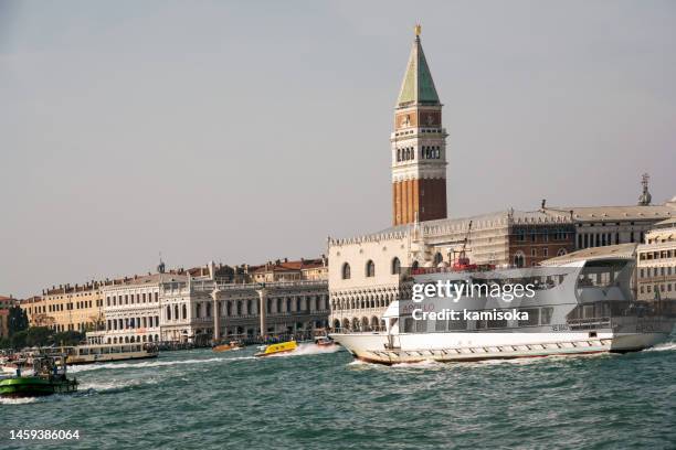 boat ferry for transporting passengers and tourists in venice and saint mark bell tower - campanile venice stock pictures, royalty-free photos & images