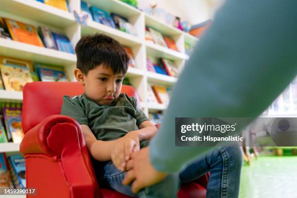 sad boy being touched in the leg at school - child fear stock pictures, royalty-free photos & images