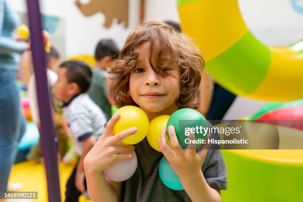 happy boy playing with balls at the playground - adult ball pit stock pictures, royalty-free photos & images