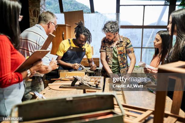 group of multiracial people learning carpentry at woodworking class - carpenter stock pictures, royalty-free photos & images