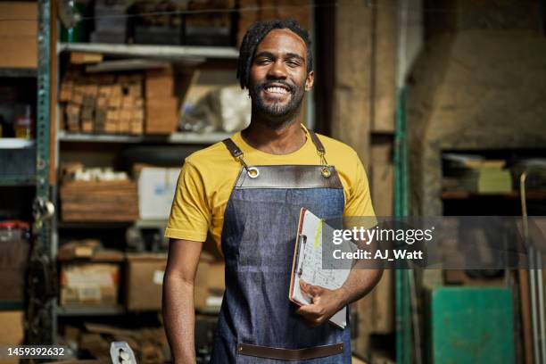 portrait of a happy young male carpenter in his workshop - timmerman stockfoto's en -beelden