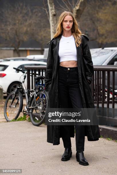 Abby Champion wears a white t-shirt, black jeans, black leather trench coat, outside Chanel, during Paris Fashion Week - Menswear Fall-Winter...