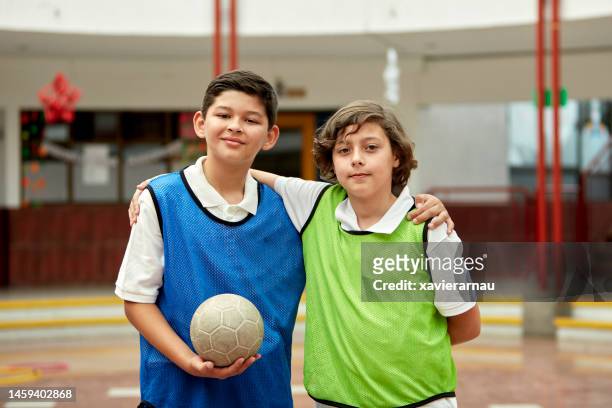 indoor-porträt von schulfreunden mit ball - fußball 2 jungs stock-fotos und bilder