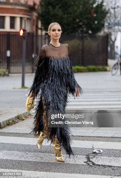 Leonie Hanne wears black dress with fringes, golden bag, golden boots outside Alexandre Vauthier during Paris Fashion Week - Haute Couture Spring...