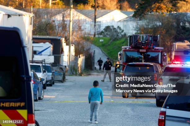 San Jose, CA A child keeps an eye on law enforcement officers as they investigate a shooting off of Highway 92 in Half Moon Bay, Calif., on Monday,...