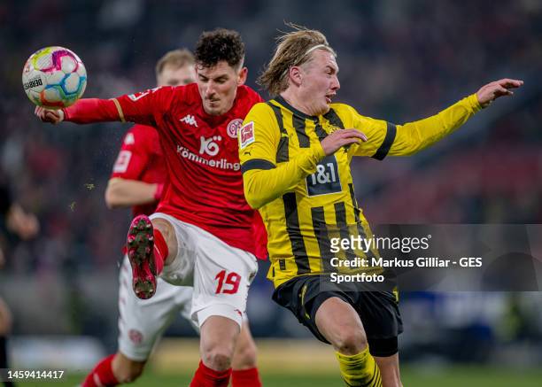 Julian Brandt of Dortmund is challenged by Anthony Caci of Mainz during the Bundesliga match between 1. FSV Mainz 05 and Borussia Dortmund at MEWA...