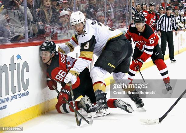 Brayden McNabb of the Vegas Golden Knights hits Jack Hughes of the New Jersey Devils into the boards during overtime at the Prudential Center on...