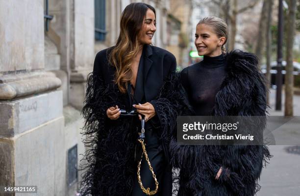Tamara Kalinic wears black coat with fringes, black bag with golden chain, black sunglasses, pants & Caroline Daur wears see trough black turtleneck,...