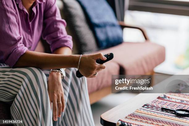an unrecognizable woman watching tv while relaxing at home - alter tv stock pictures, royalty-free photos & images