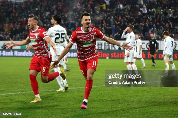 Mergim Berisha of FC Augsburg celebrates after scoring the team's first goal during the Bundesliga match between FC Augsburg and Borussia...