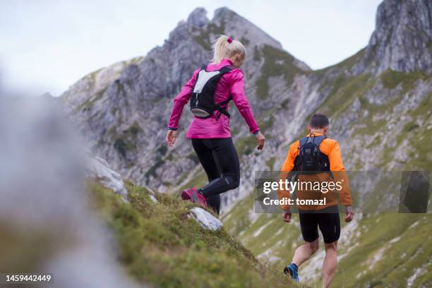 mountain running couple - downhill skiing stock pictures, royalty-free photos & images