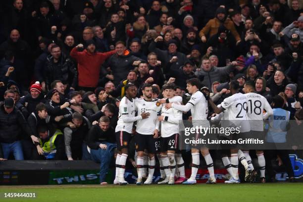 Bruno Fernandes of Manchester United celebrates with teammates after scoring the team's third goal as fans knock over the advertising boards during...