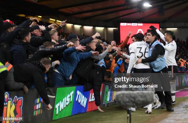 Manchester United fans celebrate and knock over the advertising boards after Bruno Fernandes of Manchester United scored their sides third goal...