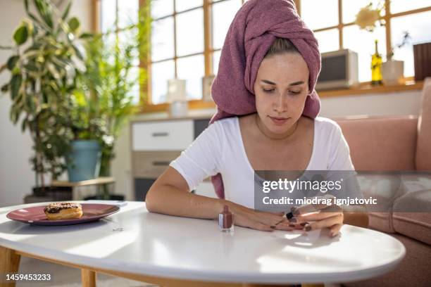 frau macht selbst maniküre - fingernägel lackieren stock-fotos und bilder