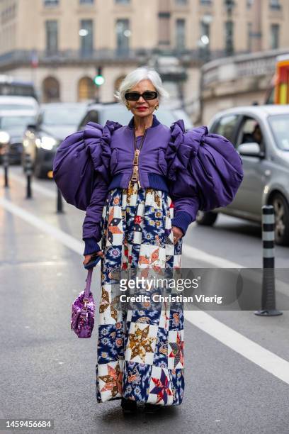 Grece Ghanem wears purple cropped zipper jacket with wide shoulders sleeves, dress with graphic print, pink Fendi bag outside Viktor & Rolf during...