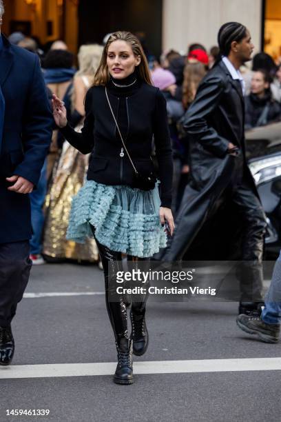 Olivia Palermo wears turquoise dress, black vinyl pants, laced shoes, black cardigan, turtleneck outside Viktor & Rolf during Paris Fashion Week -...