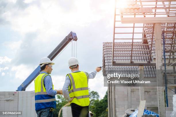 engineer use tablet working with new house on construction site. - herbouwen stockfoto's en -beelden