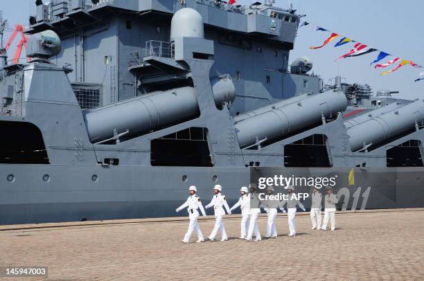 Chinese sailors march pass the Russian destroyer Admiral Vinogradov berthed at the People's Liberation Army naval base in Qingdao, northeastern...