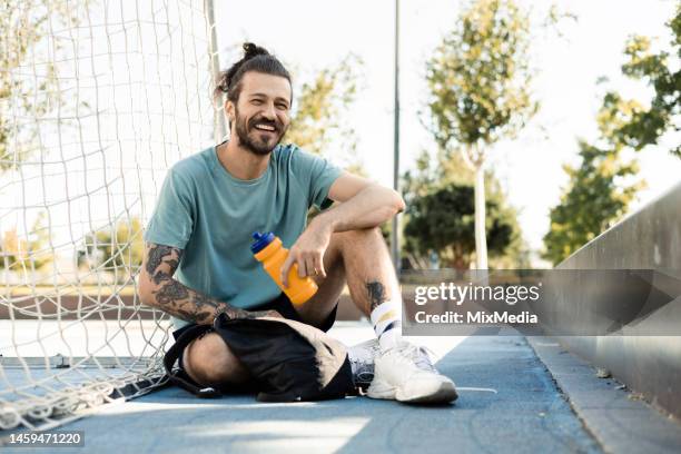 young man cooling down after playing soccer - coolingdown stockfoto's en -beelden