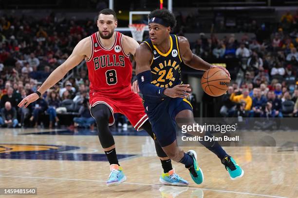 Buddy Hield of the Indiana Pacers dribbles the ball while being guarded by Zach LaVine of the Chicago Bulls in the third quarter at Gainbridge...