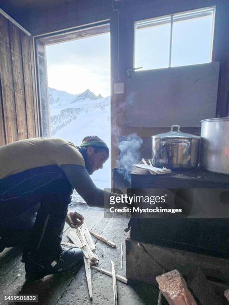 mountaineer cooking in mountain hut - ski hut stock pictures, royalty-free photos & images