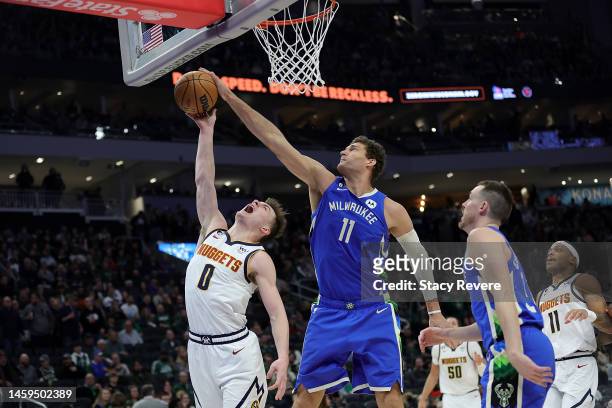 Brook Lopez of the Milwaukee Bucks blocks a shot by Christian Braun of the Denver Nuggets during the second half of a game at Fiserv Forum on January...