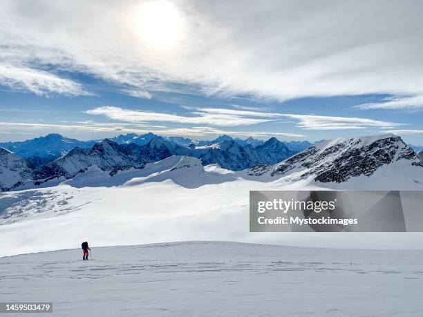 one man backcountry skiing in switzerland, mountain range in distance - ski touring stock pictures, royalty-free photos & images