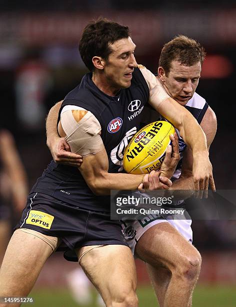 Steve Johnson of the Cats tackles Michael Jamison of the Blues during the round 11 AFL match between the Carlton Blues and the Geelong Cats at Etihad...