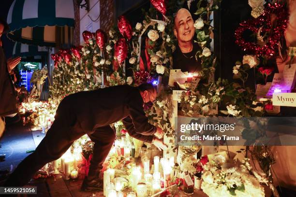 Victims' pictures are displayed at a candlelight vigil at the growing memorial outside the Star Ballroom Dance Studio where a deadly mass shooting...