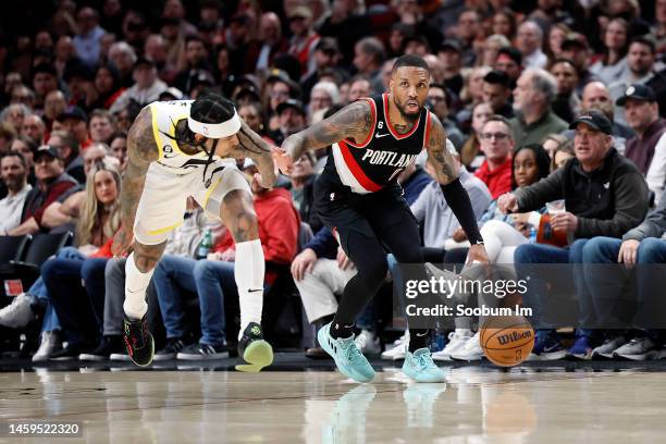 Damian Lillard of the Portland Trail Blazers dribbles the ball while defended by Jordan Clarkson of the Utah Jazz during the second half at Moda...