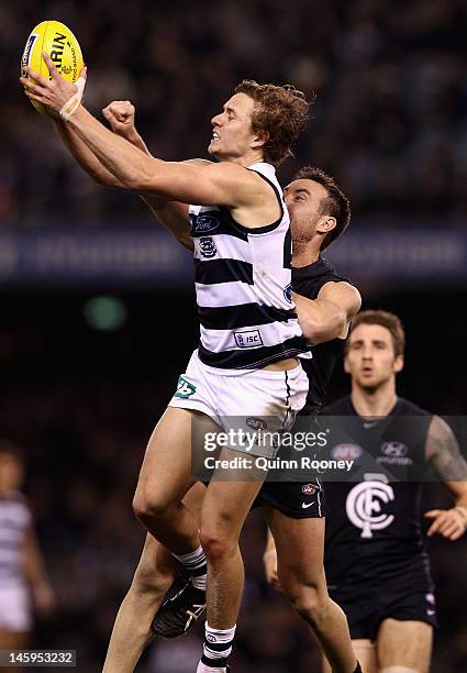 Mitch Duncan of the Cats marks infront of Brock McLean of the Blues during the round 11 AFL match between the Carlton Blues and the Geelong Cats at...