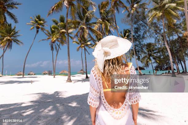 vista trasera de la mujer despreocupada en el día de verano en la playa. - zanzibar fotografías e imágenes de stock