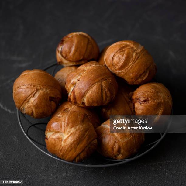 small round buns. fresh sweet pastries from yeast dough. buns for breakfast. sweets in metal plate on table. dark background. view from above. copy space - profiterole stock pictures, royalty-free photos & images