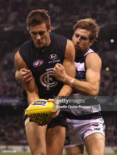 Tom Lonergan of the Cats tackles Shaun Hampson of the Blues during the round 11 AFL match between the Carlton Blues and the Geelong Cats at Etihad...