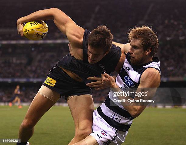 Tom Lonergan of the Cats tackles Shaun Hampson of the Blues during the round 11 AFL match between the Carlton Blues and the Geelong Cats at Etihad...